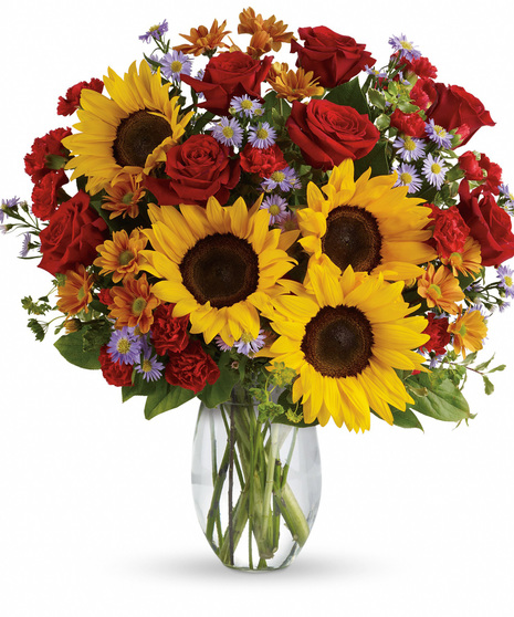 A bouquet featuring red roses, sunflowers, and other foliage.
