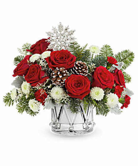 Red and white flowers in a large holiday ornament shaped container.